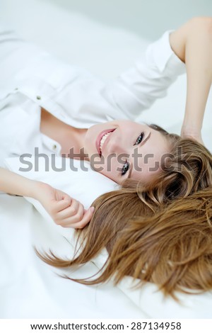 young woman sleeping on the white linen in bed at home, top view