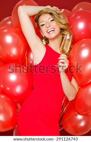 Beautiful woman with a glass of champagne. Holiday balloons.