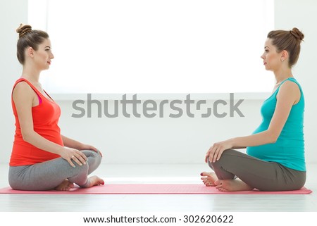 Prenatal exercise. Beautiful pregnant woman performing yoga