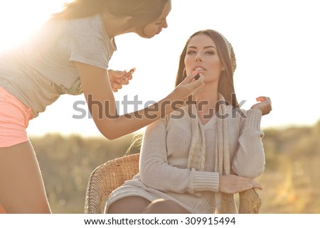 make up artist doing professional make up of young woman