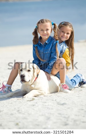 The girl with the dog on the shore of the sea. The child and a dog.