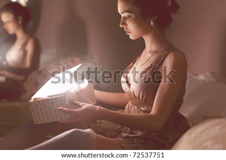 Beautiful girl with a gift in the room at night
