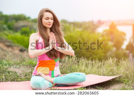 Peaceful healthy & fit young woman meditating on the nature with eyes closed
