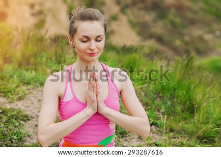 Peaceful healthy & fit young woman meditating on the nature with eyes closed