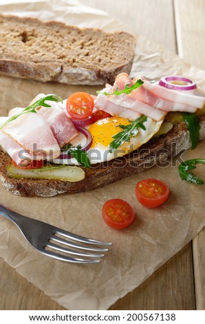 Bacon and fried egg open sandwich on the table