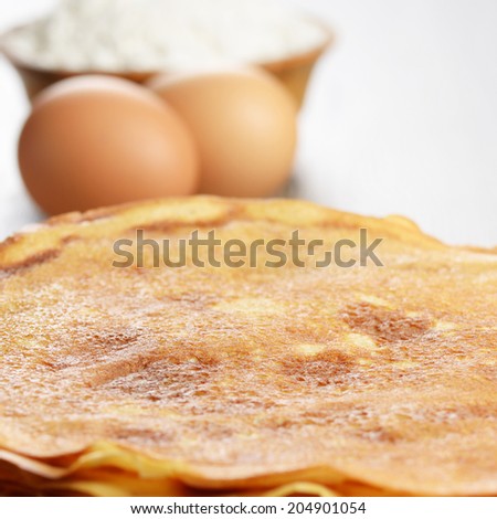 Homemade eggs, pancakes and flour on the wooden table