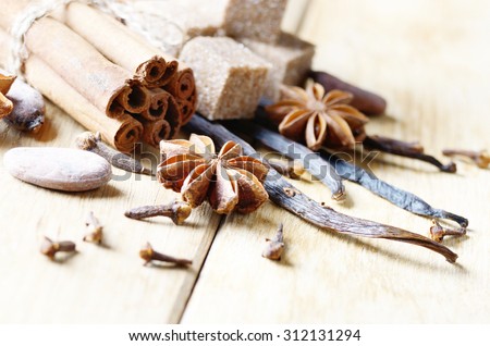 Vanilla, cinnamon, cocoa, anise and cloves on wooden table