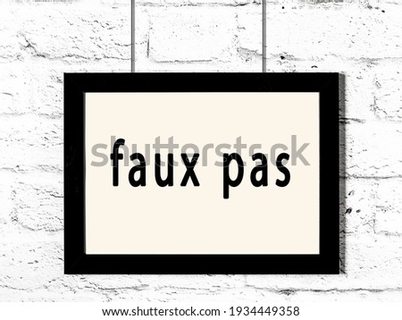 Black wooden frame with inscription faux pas hanging on white brick wall  ストックフォト © 