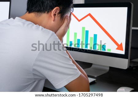 Stressed holding face with his hands because having trouble. Bankrupt Asian Male is sitting with computer and paperwork on desk at workplace in office. Business Mistake Financial. 商業照片 © 