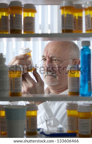 Man intently reading label on prescription bottle