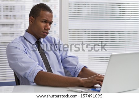 Young African-American businessman stressed at work, horizontal