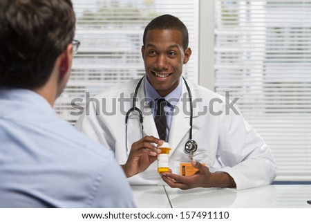 Young black doctor showing patient prescription, horizontal