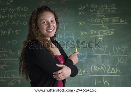 Young woman standing in front of a chalkboard in a classroom