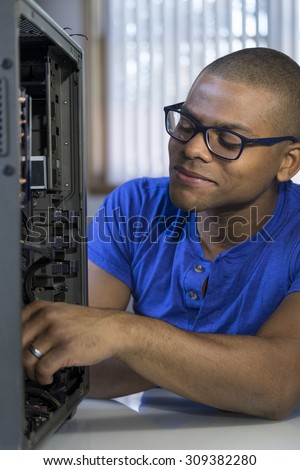 African American computer technician repairing a computer