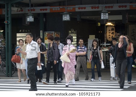 KYOTO, JAPAN - JUNE 22: Maiko in kimono on the way to work June 22, 2012 in Kyoto, Japan. Maiko is a geisha apprentice, a popular form of Japanese entertainment, left from the medieval times.