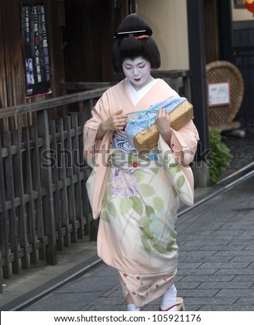 KYOTO, JAPAN - JUNE 22: Maiko in kimono on the way to work June 22, 2012 in Kyoto, Japan. Maiko is a geisha apprentice, a popular form of Japanese entertainment, left from the medieval times.