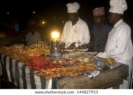 STONE TOWN, ZANZIBAR - FEBRUARY 5 : Night market 5 february, 2011. Stone Town, Zanzibar. Cooks prepare grilled seafood during the night market for the customers on the beach in Stone Town.