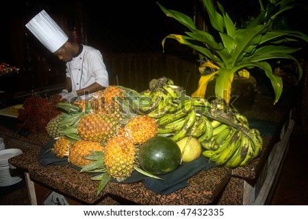 KIWENGWA, ZANZIBAR - FEBRUARY 10: Local cook cutting fruits for guests in a hotel restaurant, February 10, 2010 in Kiwengwa, Zanzibar, Tanzania.