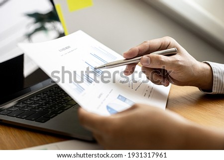 Business men are looking at the company's financial documents to analyze problems and find solutions before bringing the information to a meeting with a partner. Financial concept.