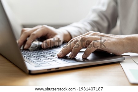 Close-up A businessman working in a private room, He is typing on a laptop keyboard, He uses a messenger to chat with a partner. Concept of using technology in communication. 商業照片 © 