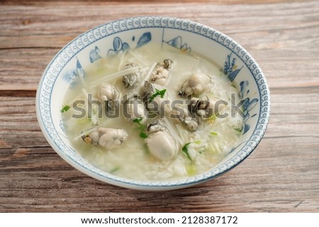 Oyster porridge (Oyster congee) served on plate. wooden background Photo stock © 