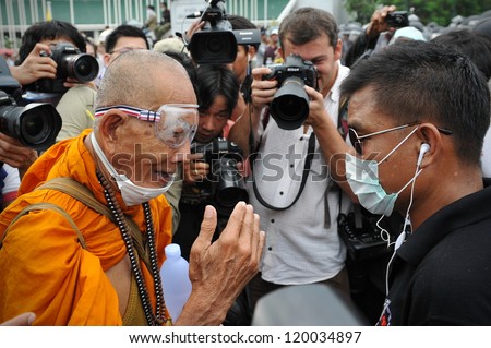 BANGKOK - NOV 24: A Buddhist monk talks with a Nationalist anti-government protester from Pitak Siam at a rally on Makhawan Bridge on Nov 24, 2012 in Bangkok, Thailand.