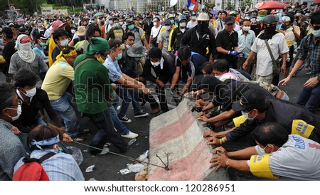 BANGKOK - NOV 24: Nationalist protesters from the Pitak Siam group remove concrete barriers from a police roadblock on during a large anti-government rally on Nov 24, 2012 in Bangkok, Thailand.