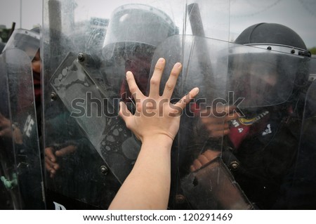 BANGKOK - NOV 24: A protester from the nationalist Pitak Siam group pushes the shield of riot police during a violent anti-government rally with riot police on Nov 24, 2012 in Bangkok, Thailand.