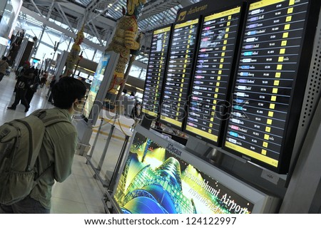 BANGKOK - SEPT 19: An unidentified man looks at the departures board at Suvarnabhumi International Airport on Sept 19, 2012 in Bangkok, Thailand. The airport handles 45 million passengers annually.