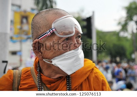 BANGKOK - NOV 24: A masked Buddhist monk attends an anti-government rally organised by the nationalist Pitak Siam group on Nov 24, 2012 in Bangkok, Thailand.