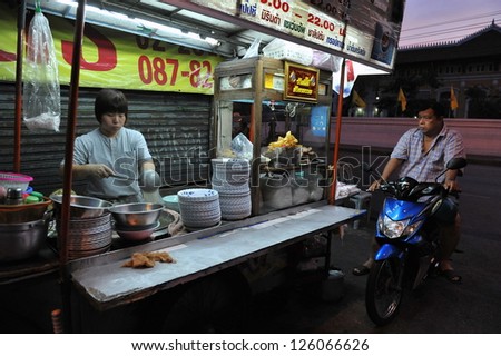 BANGKOK - JAN 3: An unidentified street vendor cooks at a night market on Jan 3, 2013 in Bangkok, Thailand. According government statistics there are over 16,000 registered street vendors in Bangkok.