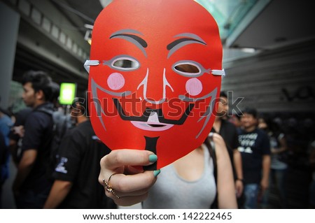 BANGKOK - JUNE 2: A protester holds a red Guy Fawkes mask as Red Shirts stage a rally in Bangkok\'s shopping district to show their support to the government on June 2, 2013 in Bangkok, Thailand.