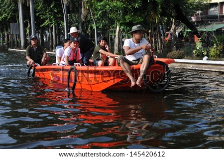 BANGKOK - NOV 4: A boat navigates a flooded road in Pinklao district in rescuing flood victims on Nov 4, 2011 in Bangkok, Thailand. The 2011 Thai floods claimed 815 lives and displaced 13.9M people.