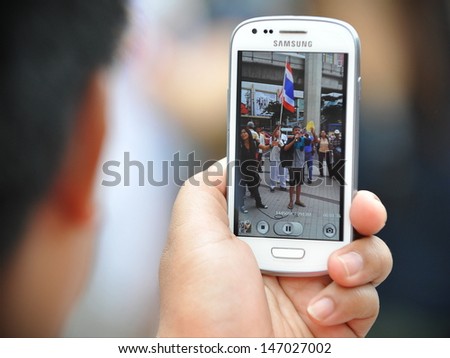BANGKOK - JULY 21: A protester uses a smartphone to video an anti-government rally on July 21, 2013 in Bangkok, Thailand. The protesters are calling for the government to be overthrown.