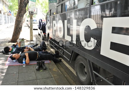 BANGKOK - AUG 1: Police rest outside Government House as the government invokes martial law amid threats to national security and planned anti-government rallies on Aug 1, 2013 in Bangkok, Thailand.