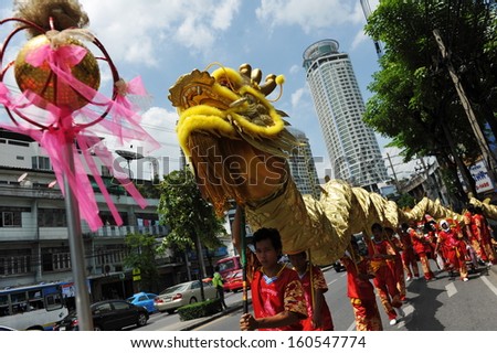 BANGKOK - JUL 21: A dragon dance troupe performs on a street on Jul 21 2012 in Bangkok, Thailand. Some Chinese temples in the Thai capital raise funds by sending troupes to visit local businesses.