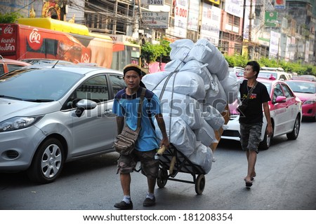 BANGKOK - MARCH 7: Unidentified workers transport goods on a city centre road on March 7, 2013 in Bangkok, Thailand. Workers transporting goods by foot often join traffic on Bangkok\'s congested roads.