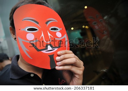 BANGKOK - JUNE 2: A masked Red Shirts joins a city centre rally in support of the government to counter a large anti government rally earlier in the day on June 2, 2013 in Bangkok, Thailand.