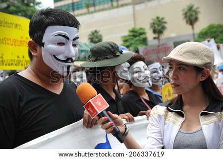 BANGKOK - JUN 2: News media interview a protester wearing a Guy Fawkes mask at a city centre anti government rally on Jun 2, 2013 in Bangkok, Thailand. Protesters call for the overthrow of government.