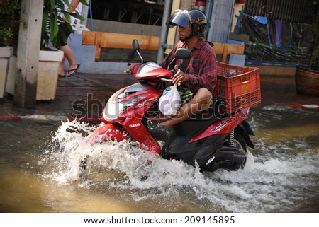 BANGKOK - NOVEMBER 1: An unidentified motorbike rider navigates a flooded street in Chinatown after the heaviest monsoon rains in over 50 years on November 1, 2011 Bangkok, Thailand.