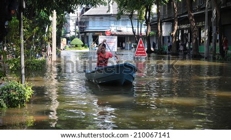 BANGKOK - NOV 1: An unidentified man rows a boat along a flooded city centre road on Nov 1, 2011 in Bangkok, Thailand. The 2011 floods claimed 815 lives and displaced millions across Thailand.