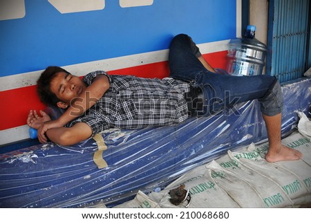 BANGKOK - NOV 1: An unidentified man sleeps on a street on Nov 1, 2011 in Bangkok, Thailand. Thailand\'s severe flooding has exacerbated homelessness with almost 14 million people displaced.