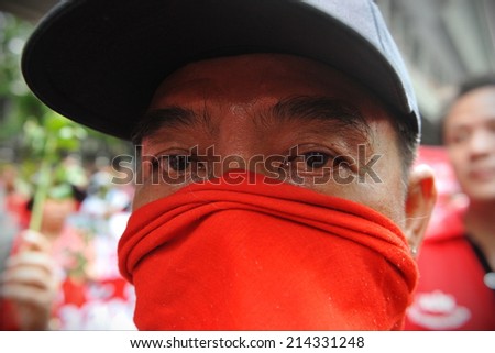 BANGKOK - MAY 19: A masked Red Shirt supporter joins a large city centre rally in remembrance of those killed in 2010 military crackdown on the political movement on May 19, 2013 in Bangkok, Thailand.