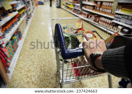Shopper Pushes a Cart in Supermarket Aisle - Image Has a Shallow Depth of Field