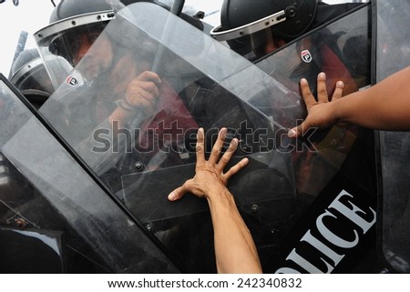 BANGKOK - NOV 24: Anti government protesters push shields of riot police during a violent a large rally on Nov 24, 2012 in Bangkok, Thailand. Protesters call for the government to be overthrown.