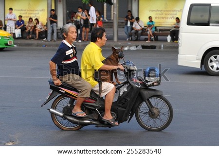 BANGKOK - MAY 30: A motorcyclist carries human and animals passengers on a city centre street on May 30, 2014 in Bangkok, Thailand. Road traffic laws are often poorly enforced and ignored in Thailand.