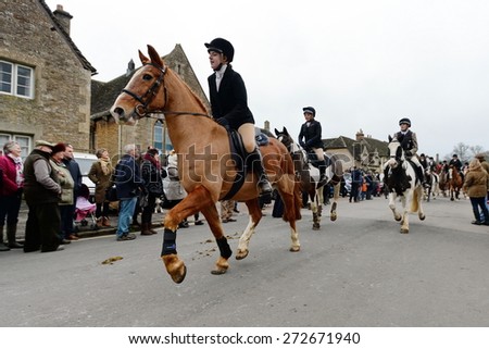 CHIPPENHAM - DEC 26: Fox hunters ride along a street during the traditional Boxing Day hunt on Dec 26, 2013 in Chippenham, UK. Fox hunting is outlawed in the UK with meets following scented trails.