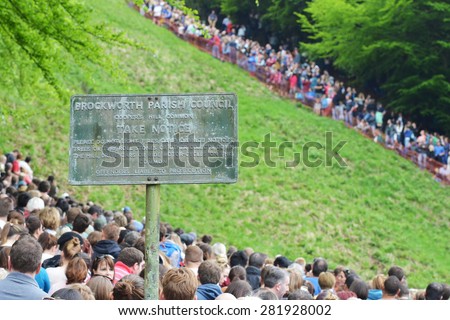 BROCKWORTH - MAY 25: Spectators gather to watch the traditional cheese rolling races on Cooper\'s Hill on May 25, 2015 in Brockworth, UK. Thousands joined the unofficial annual Gloustershire event.