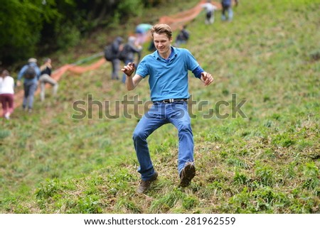 BROCKWORTH - MAY 25: A revellers joins the traditional cheese rolling races on May 25, 2015 in Brockworth, UK. Thousands attended the unofficial annual event which dates back to at least 19th century.