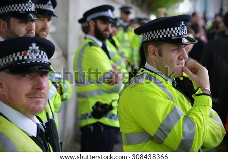LONDON - MAY 30: Police stand guard during a rally against government public sector spending cuts following the re-election of the conservative party on May 30, 2015 in London, UK.